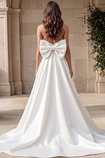 Elegant wedding dress with bow detail and flowing skirt