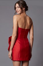 Strapless red satin mini dress featuring a structured bodice and a large decorative bow with a shimmering rhinestone buckle at the waist.