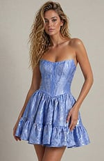 Modern corset-style cocktail dress in a periwinkle metallic fabric with a structured bust and flared hem.