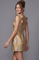 Gold metallic floral brocade mini dress featuring feminine ribbon-tie shoulder straps and a structured corset bodice.