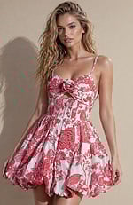 Short formal dress in red and cream floral fabric featuring a unique cutout under the bust and a textured jacquard finish.