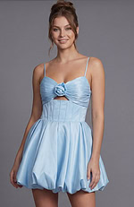 blue satin mini dress with a fabric rose accent at the bust and a dramatic rounded skirt silhouette.