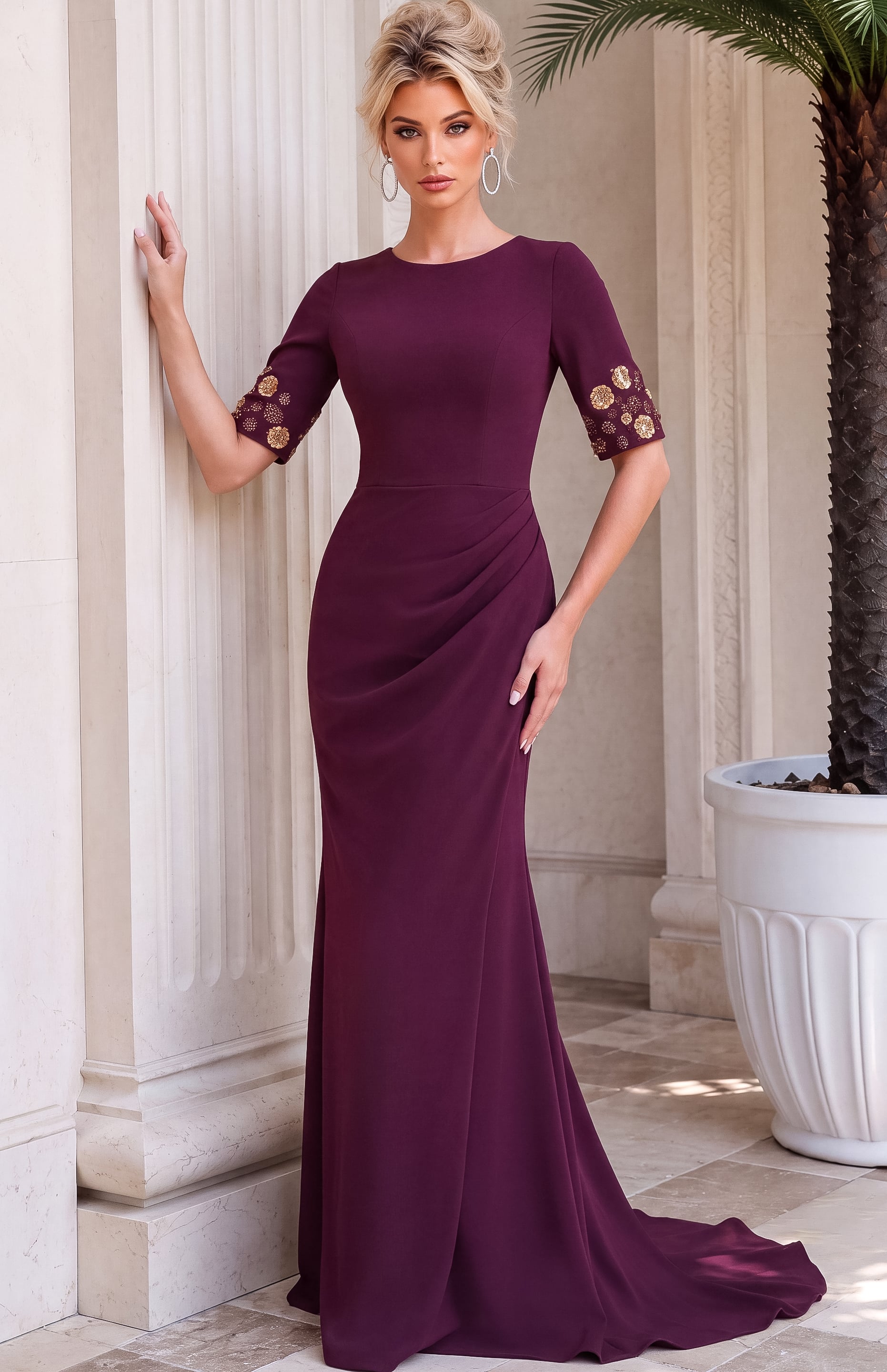 Burgundy floor-length fitted gown with a round neckline, draped waist, three-quarter sleeves, and gold floral embellishments at the cuffs.