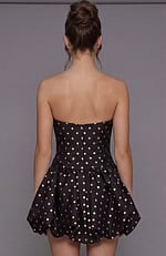 Rear view of a gold polka dot bubble dress showing the fitted bodice with a hidden zipper and voluminous skirt.