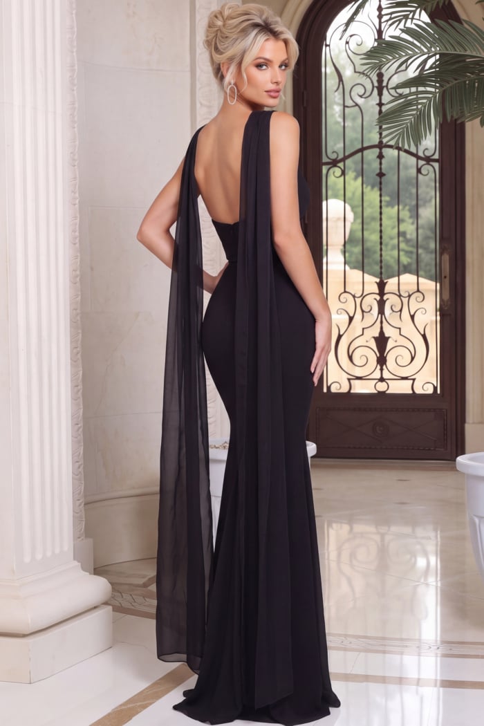Back of a black mermaid gown showing a deep scooped opening and trailing sheer scarf panels