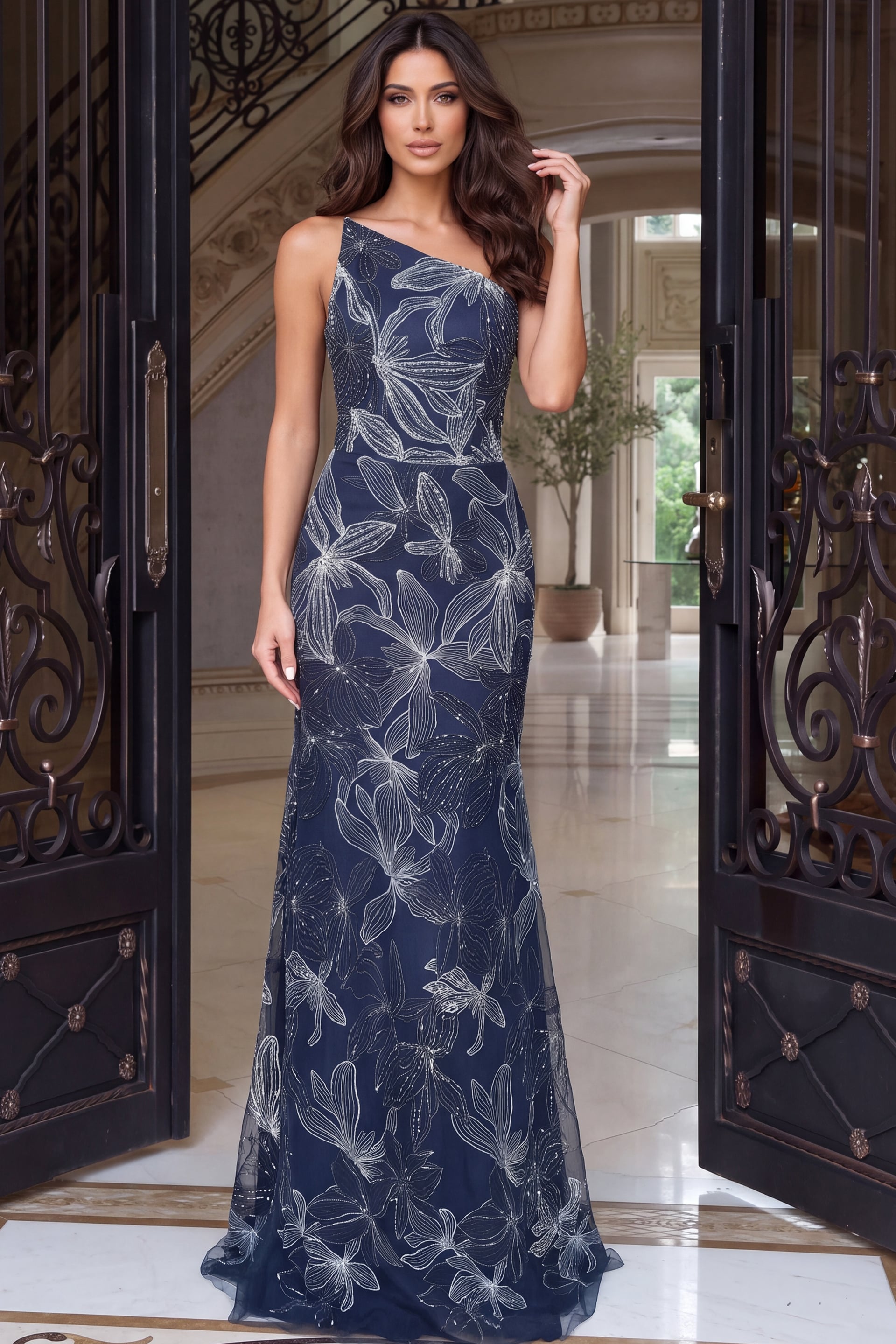 One-shoulder navy gown in silver-embroidered tulle, fitted through the hips to a train
