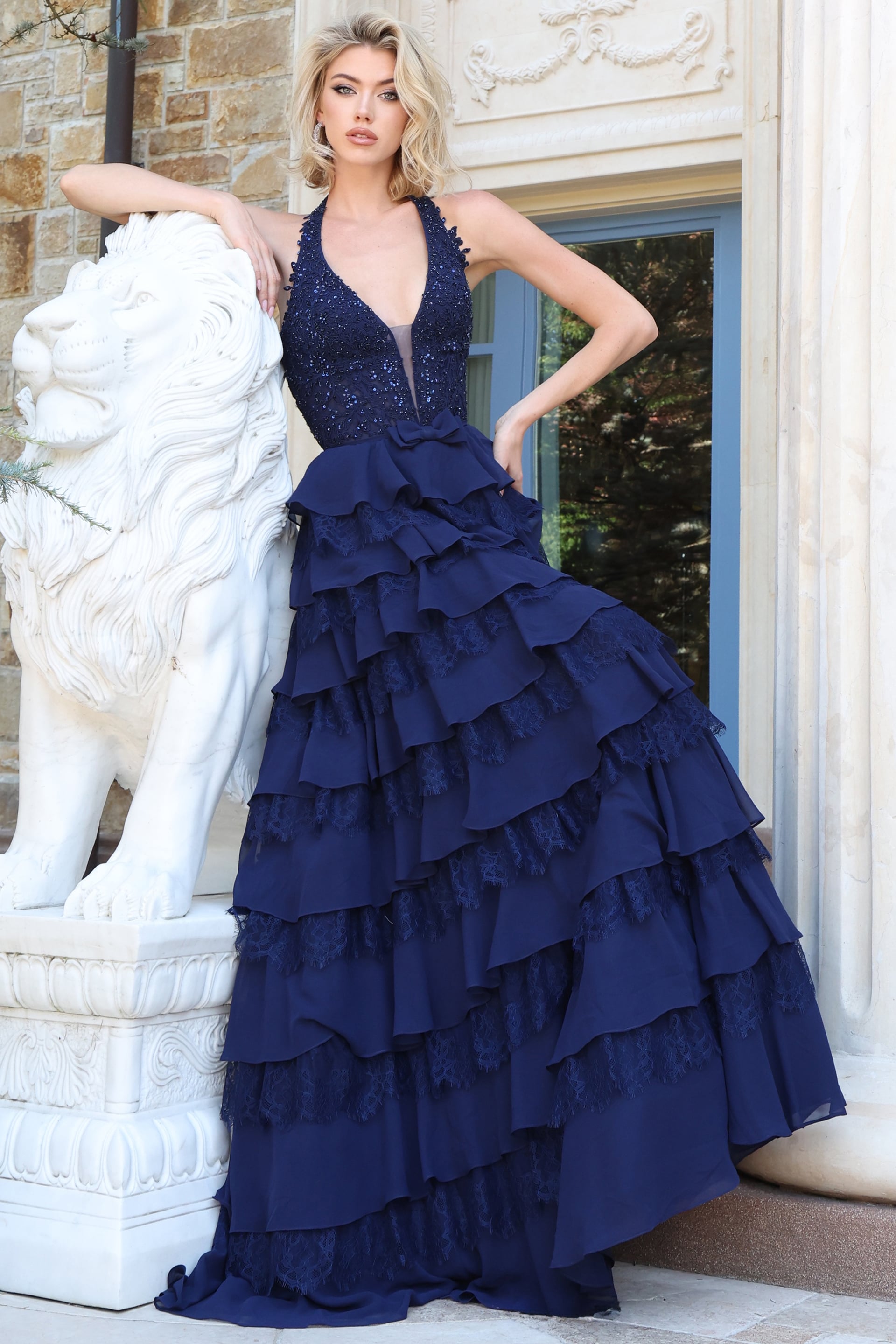 Navy beaded halter gown with plunging neckline and tiered ruffle chiffon skirt, front view