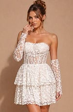 Strapless mini dress featuring a sheer corset-style bodice and a tiered skirt covered in delicate 3D floral lace.