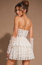 Elegant strapless silhouette with a cinched waist and a feminine, flared skirt featuring textured floral motifs.