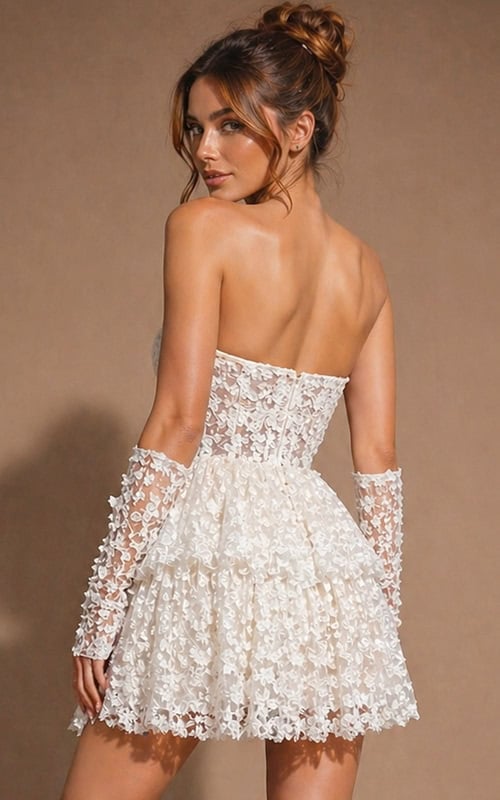 Elegant strapless silhouette with a cinched waist and a feminine, flared skirt featuring textured floral motifs.