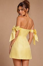 Short evening dress with a clean straight neckline and statement ribbons tied into large bows on the upper arms.
