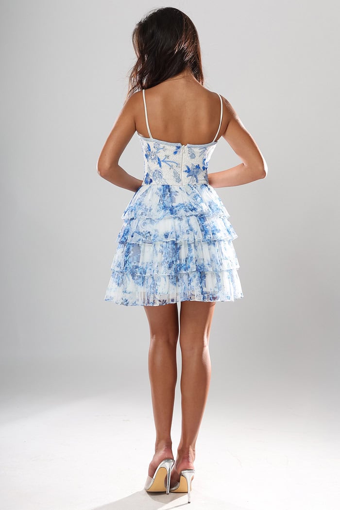 back view of white and blue floral beaded short homecoming dress with plunging V neckline, spaghetti straps and tiered ruffle skirt, Jovani style 52444