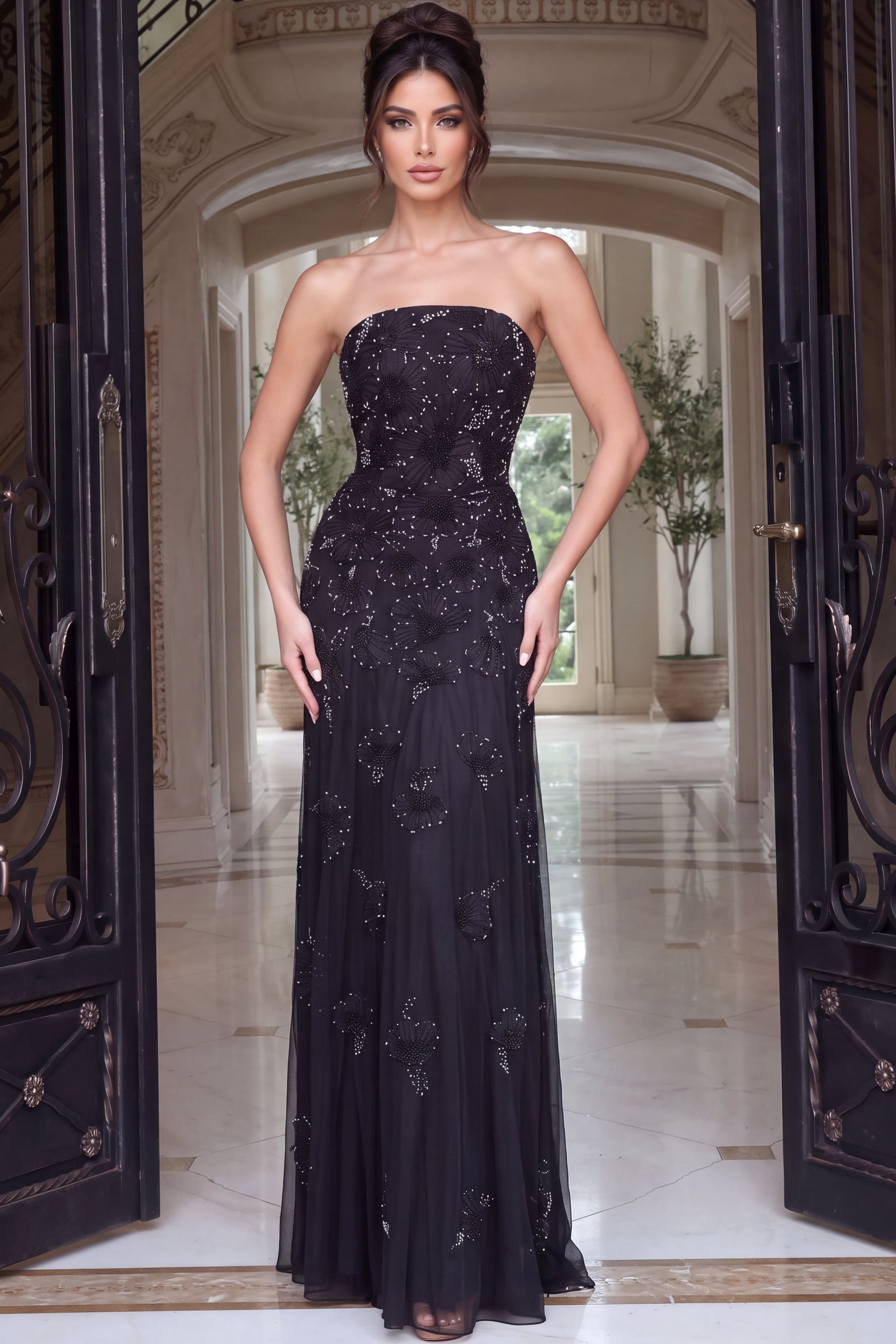 Black tulle gown with straight strapless neckline and beaded floral motifs drifting down skirt
