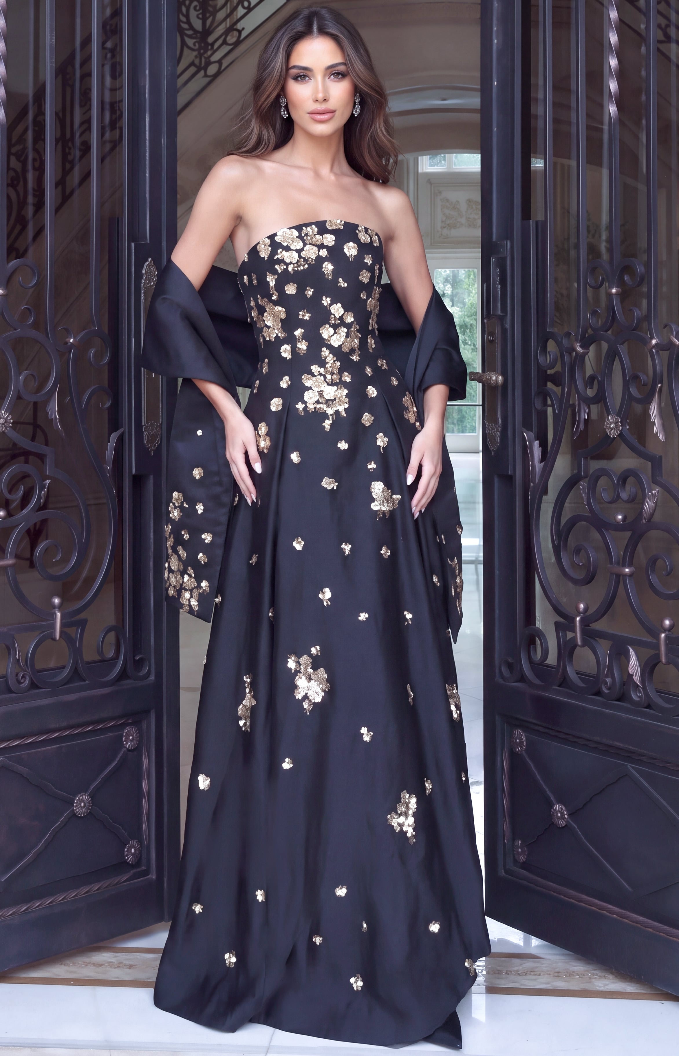 Gold sequinned blossoms scattered over a black strapless A-line gown worn with a matching stole