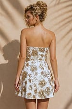 back view of ivory and gold floral strapless fit and flare mini dress