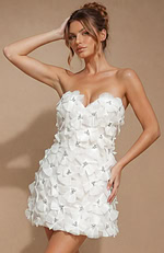 Chic ivory mini dress featuring a defined waistline and a playful, celebratory look with unique pleated floral details.