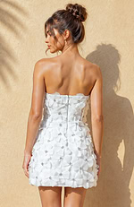 Detailed view of an ivory 3D floral dress highlighting the intricate pleating of the petals and the sparkle of the central beads.