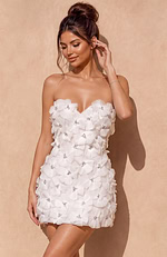 Modern white cocktail dress designed with a hidden back zipper and a glamorous, textured surface that catches the light.