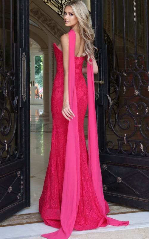 Side view of fuchsia lace trumpet gown showing the chiffon cape streamers and sweep train