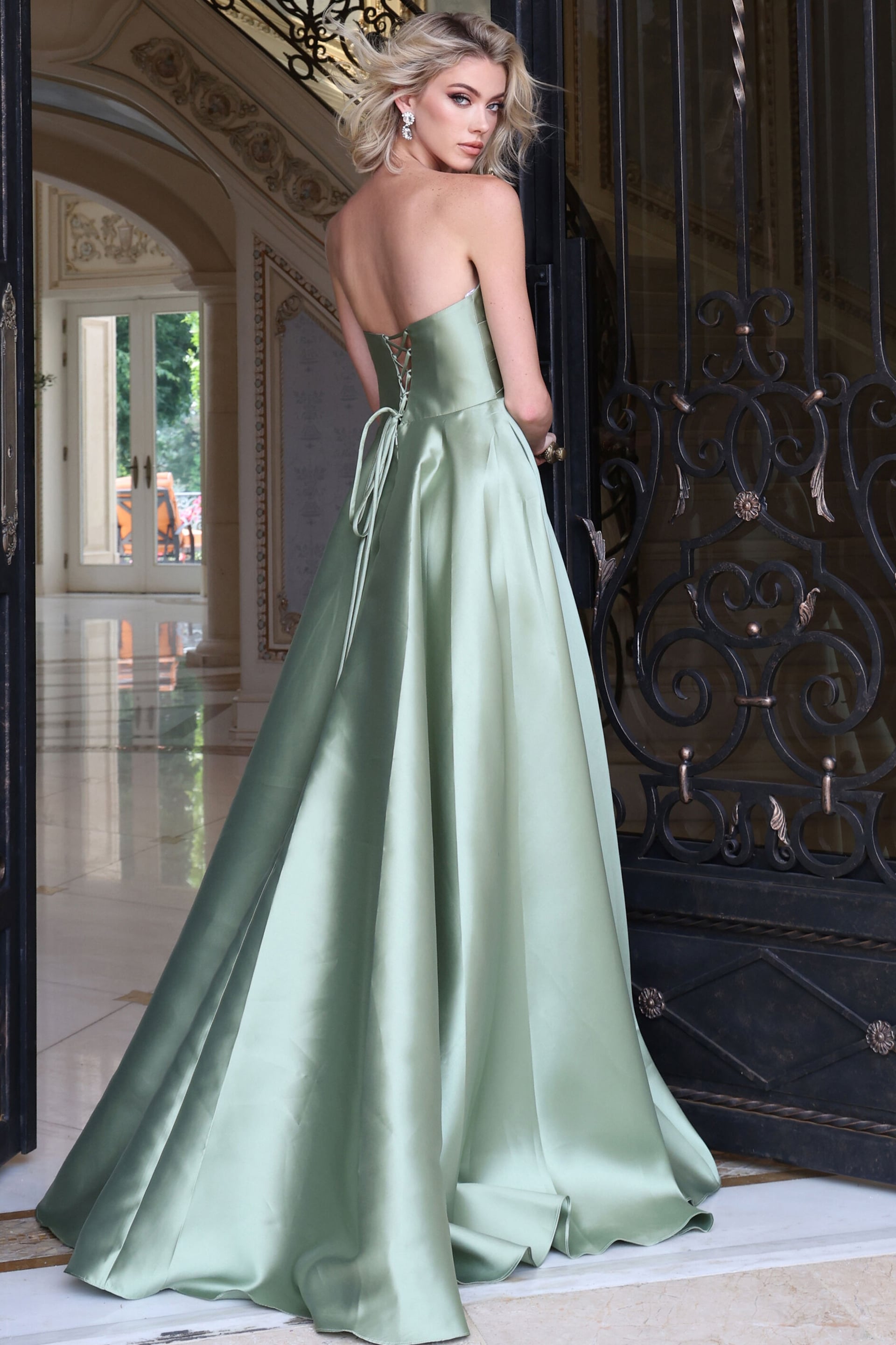 Back view of sage satin A line gown showing closed zip back and sweep train