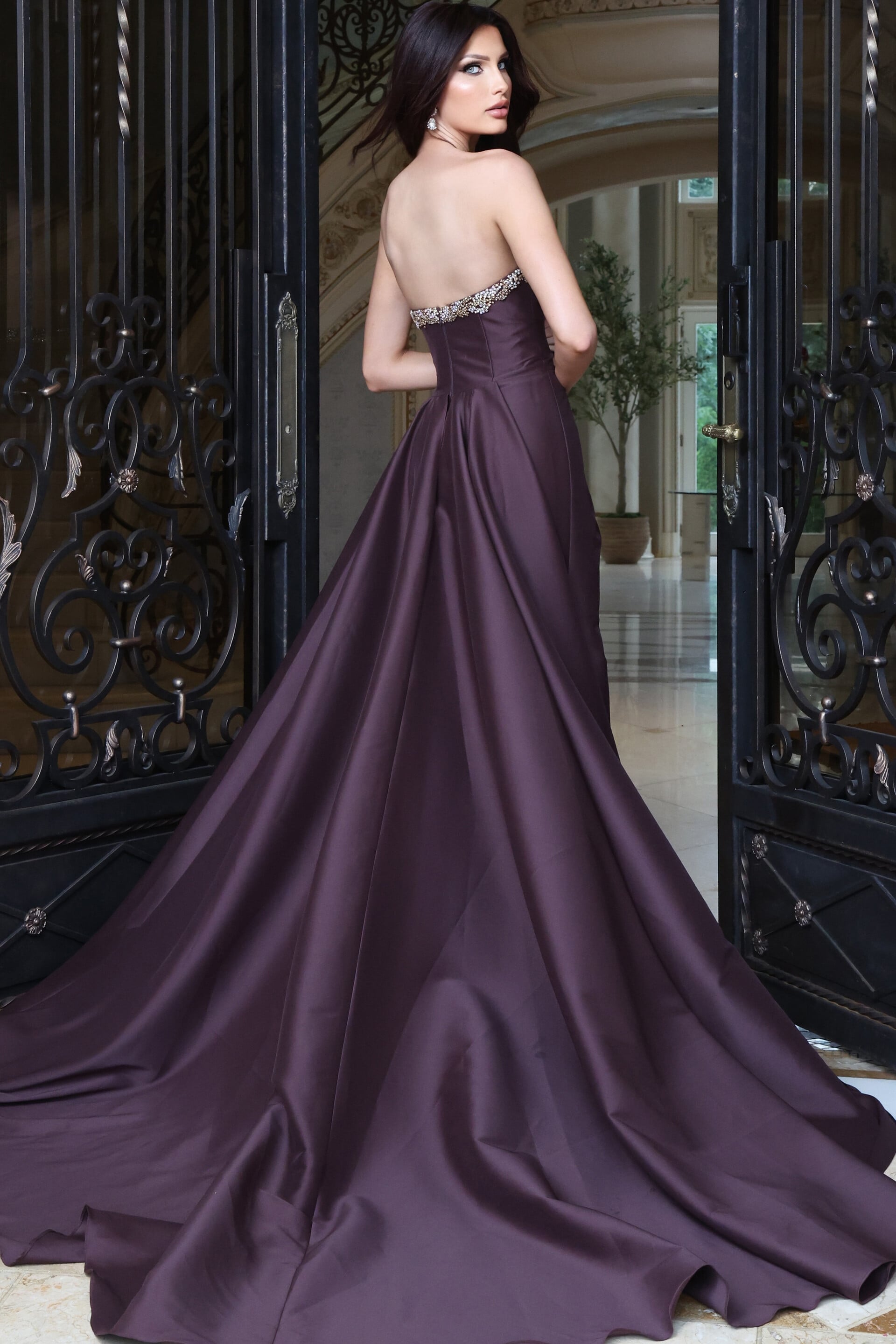 Deep aubergine satin ball gown with beaded strapless bodice and long train, side view