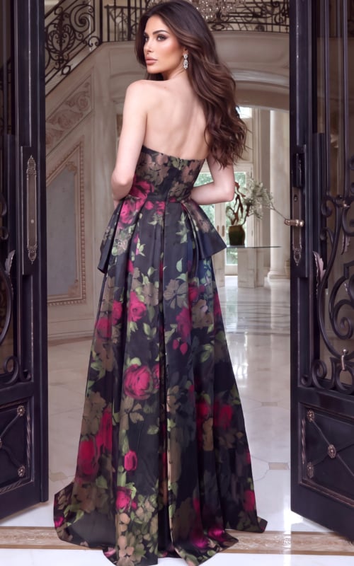 Rear angle showing an open back floral gown with peplum drape and pleated skirt