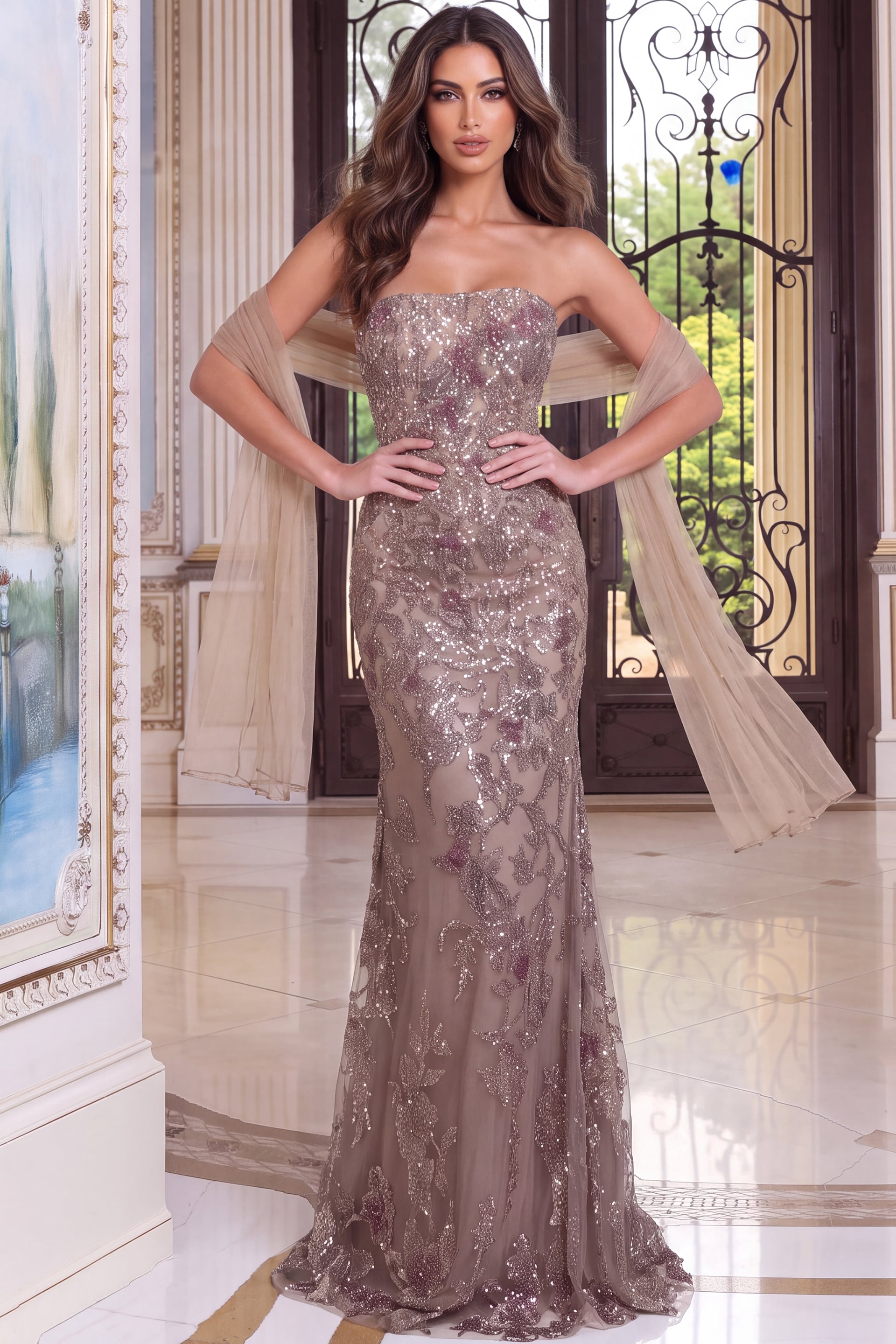 Mocha strapless gown embroidered with glitter blooms, worn with a wide tulle stole across the arms