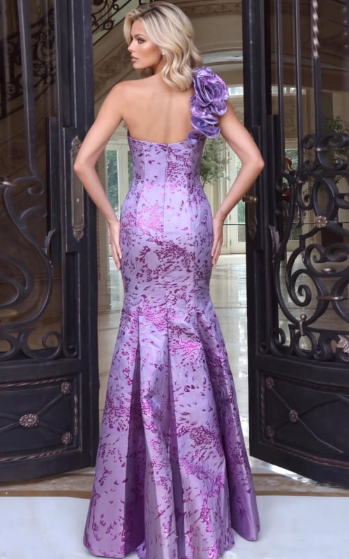 Reverse view of a lilac brocade mermaid gown with rosette shoulder and sweeping train