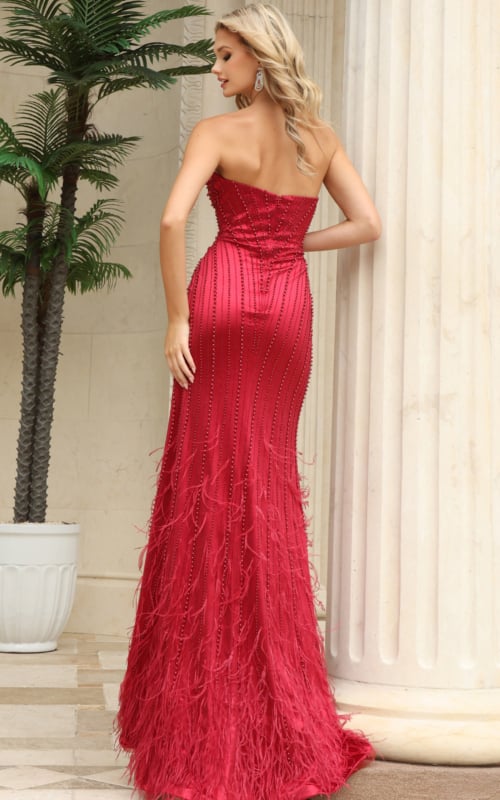 back view of red beaded gown with bare open back, fitted mermaid shape and feather trim hem 53576