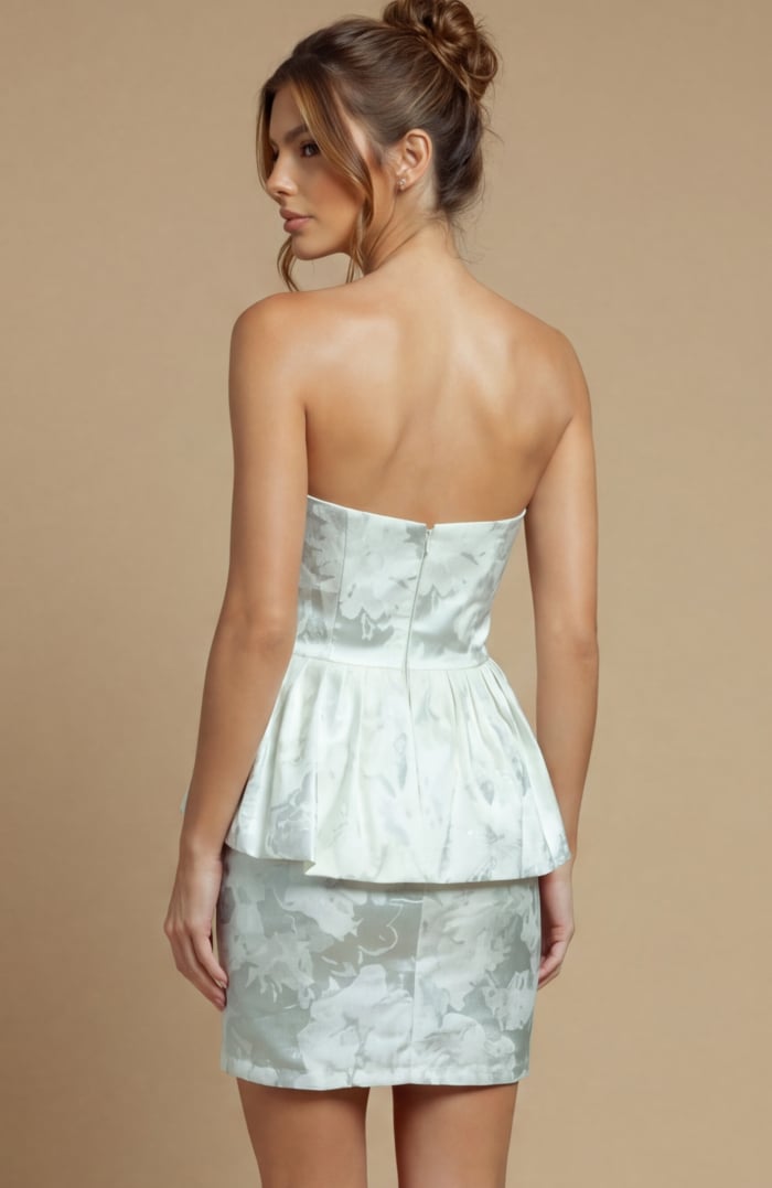 Modern strapless attire in a dense floral weave, blending a minimalist top with a bold, layered waist feature.
