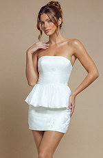 White evening dress featuring a reinforced bodice for a tailored fit and a sculptural, ruffled peplum hemline.
