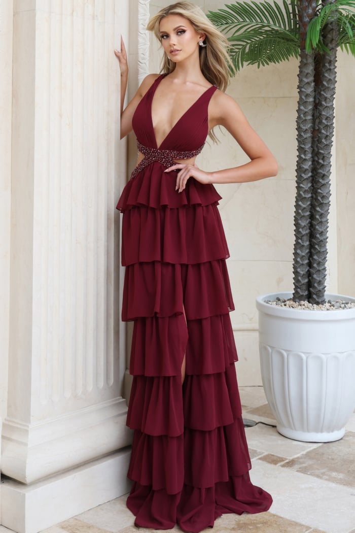 Burgundy plunging V neck gown with hand on hip showing beaded waist detail