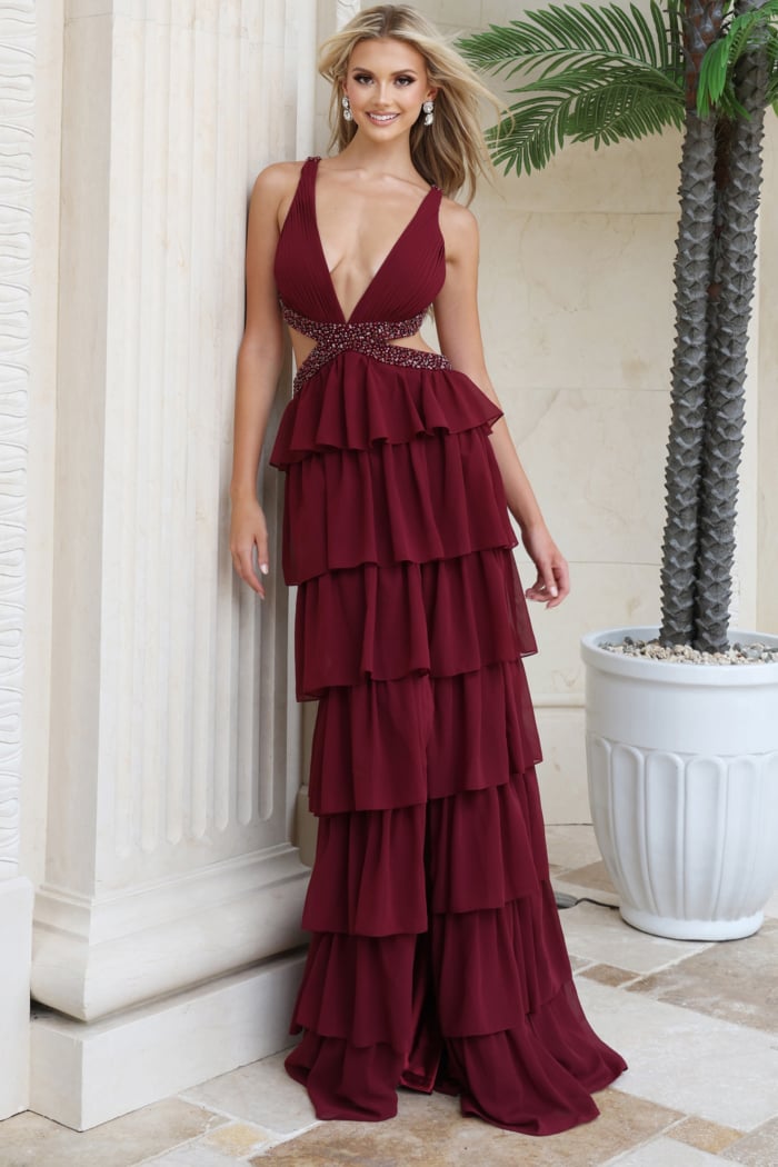 Burgundy chiffon gown leaning against a column showing the full tiered skirt