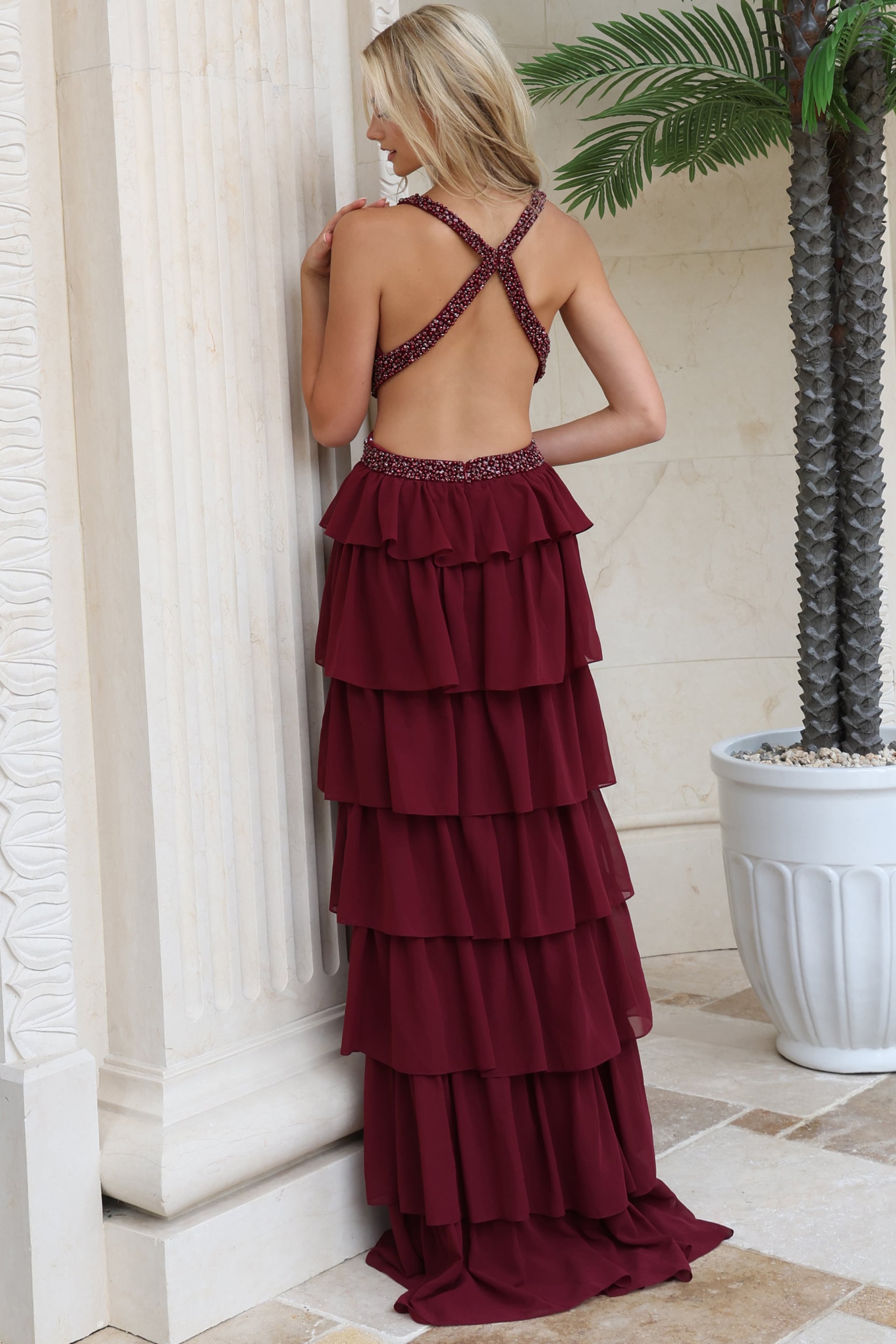 Back view of burgundy tiered chiffon gown showing crisscross open back
