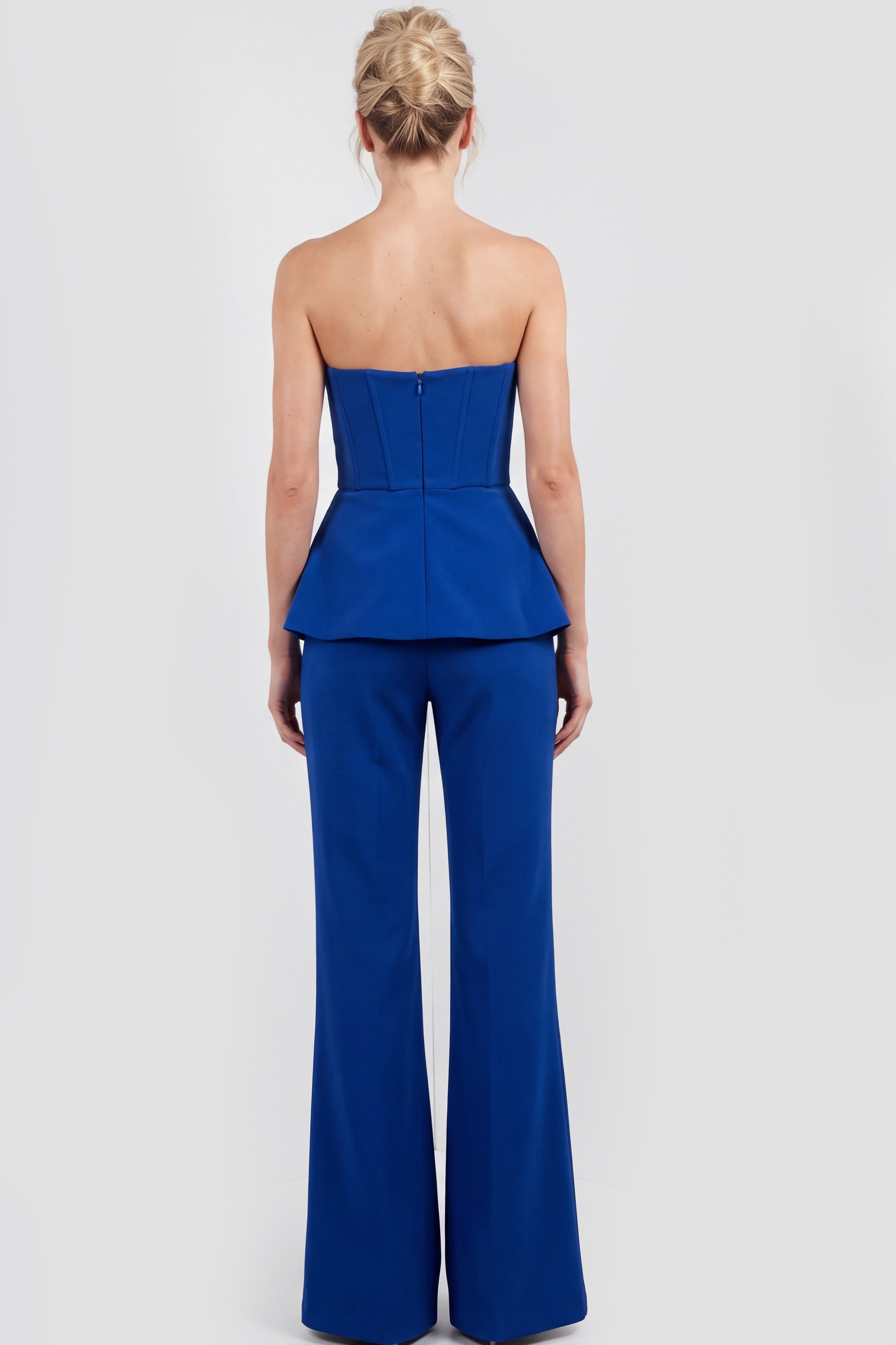 Blue sleeveless pantsuit with structured neckline and dramatic flare pants.
