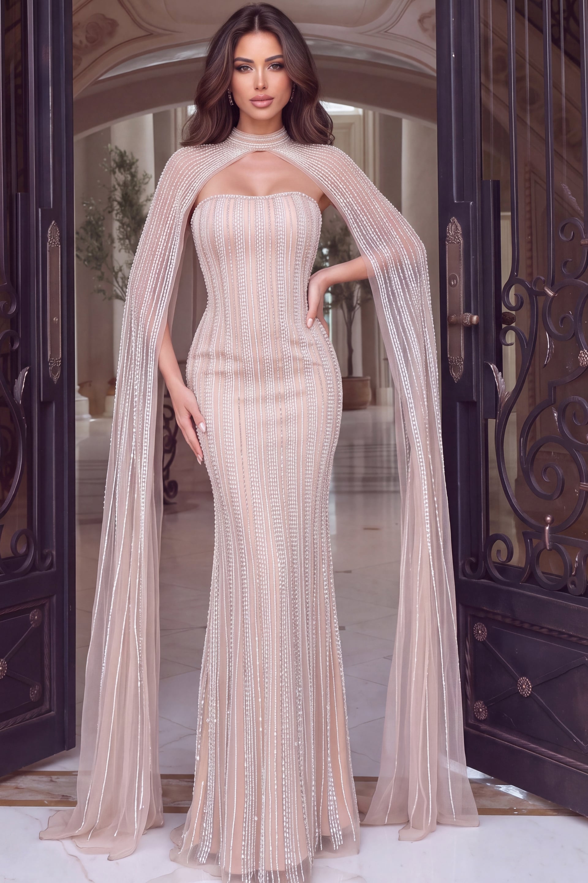 Sheer caped gown in champagne tulle, crystal stripes tracing a strapless fitted silhouette