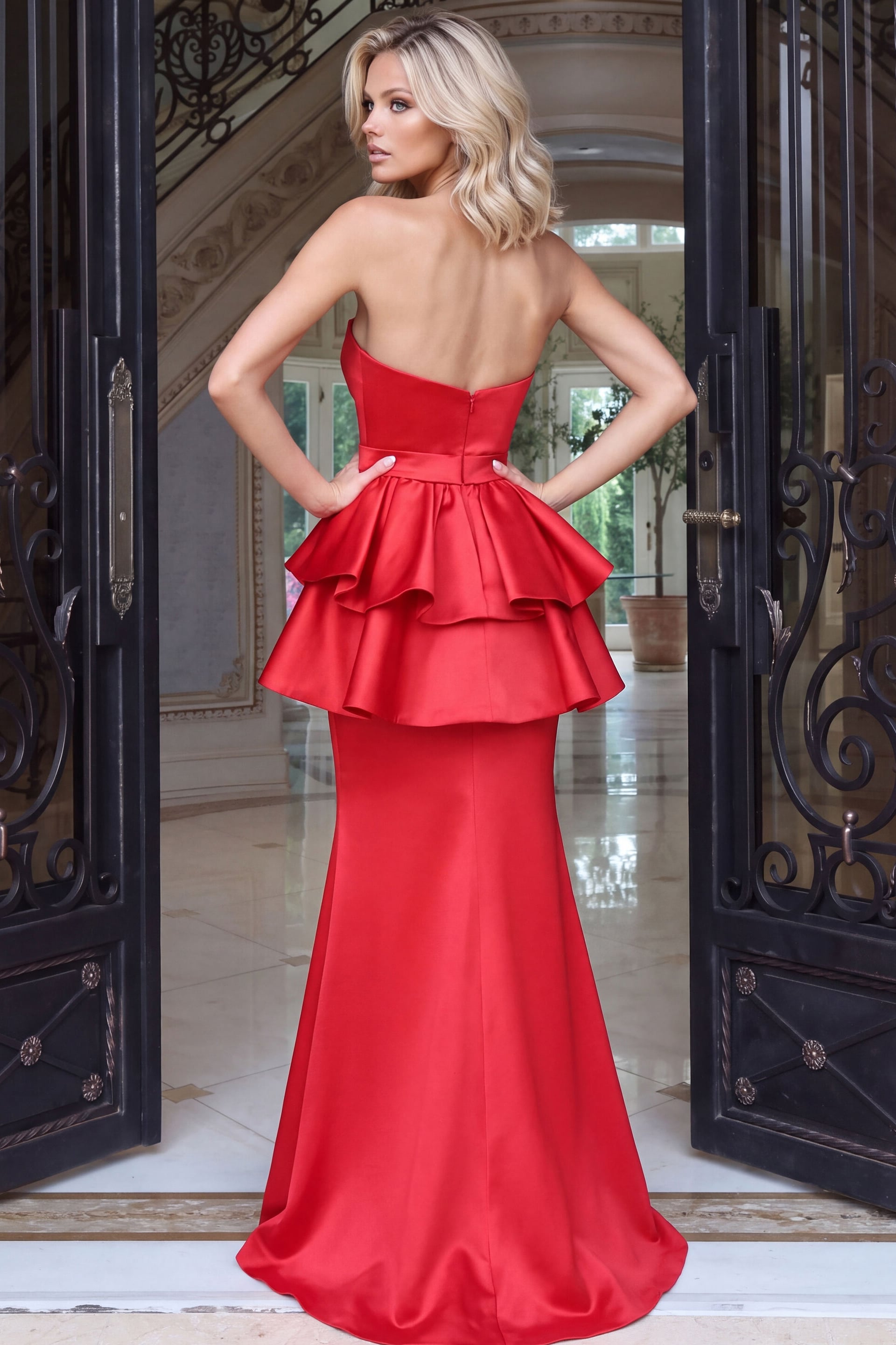 Zipper, bare shoulders and a tiered peplum on a red satin gown, rear view