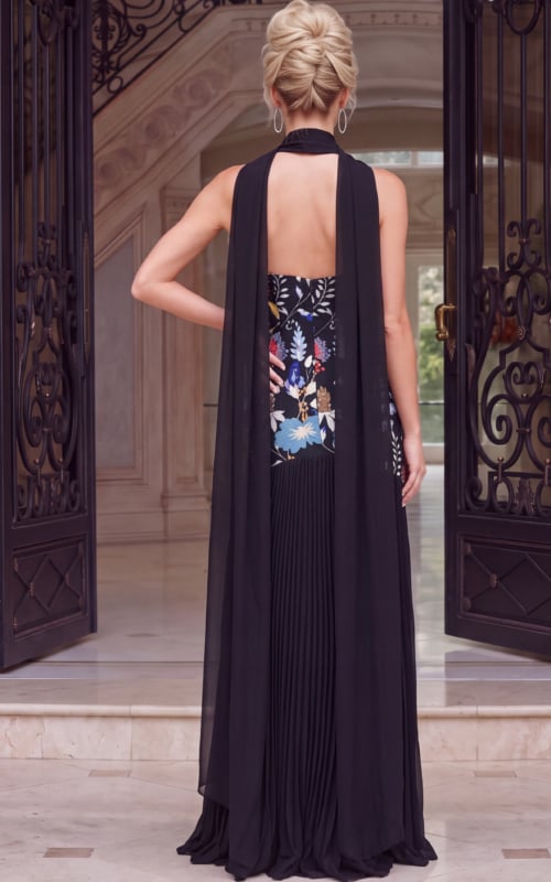 Black evening gown with colorful floral bodice and flowing pleats.