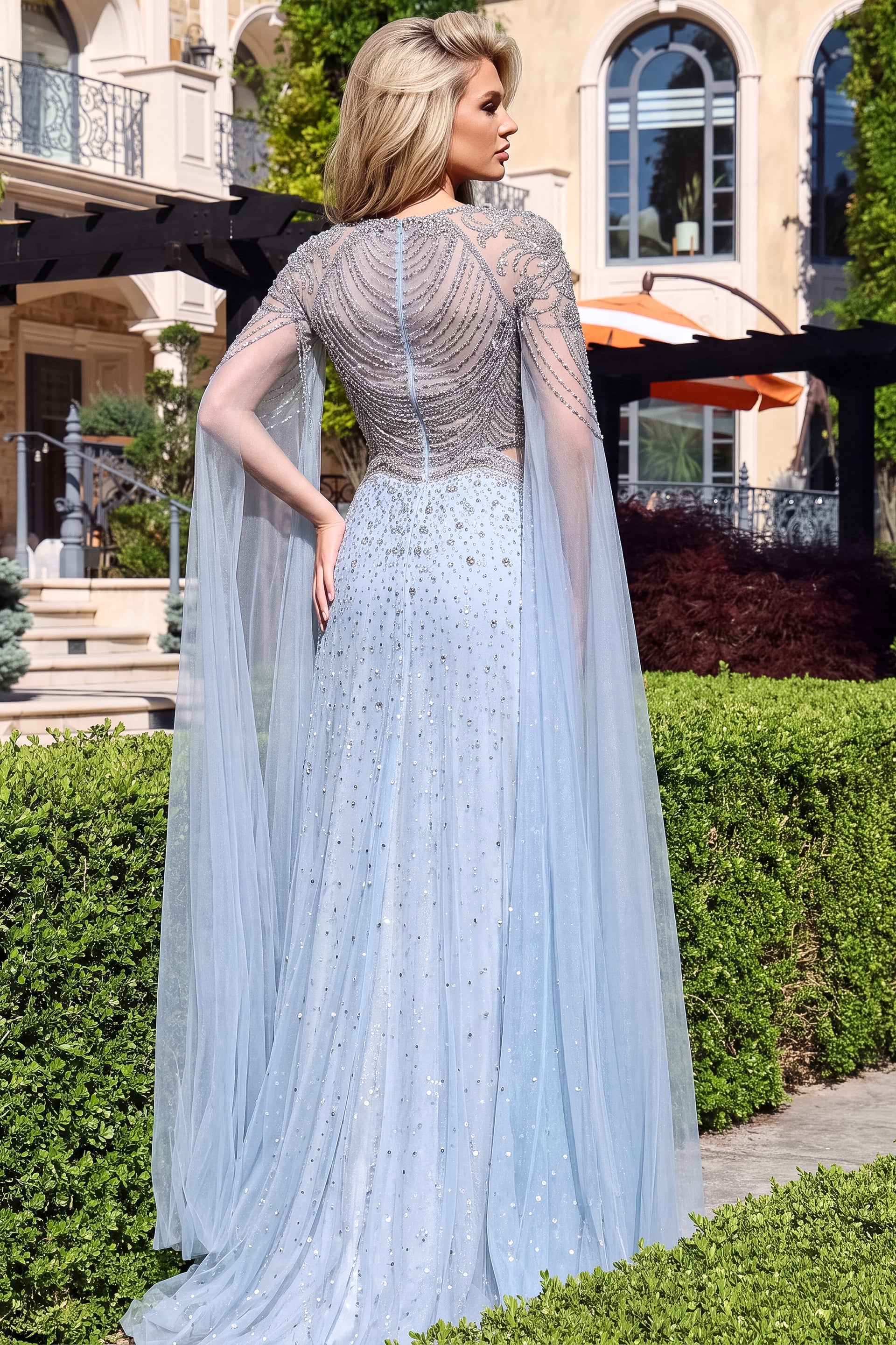 back view of blue tulle square neck a line gown with cape sleeves and draped beaded bodice