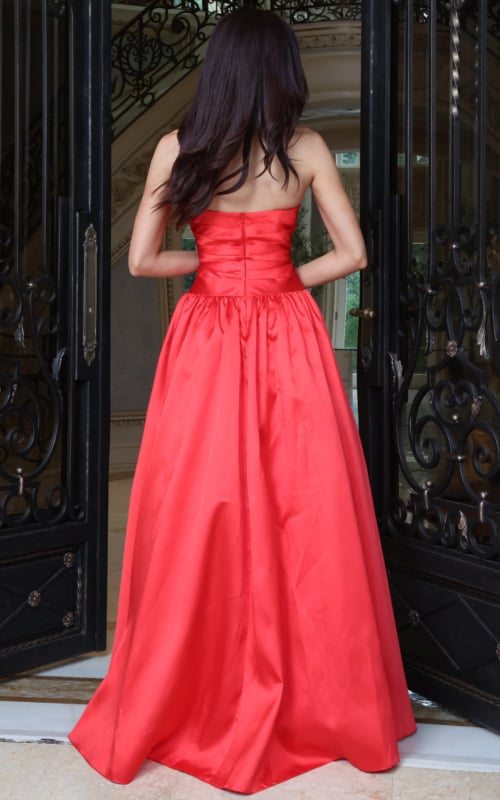 Red satin strapless ball gown with structured pleated bodice, back view