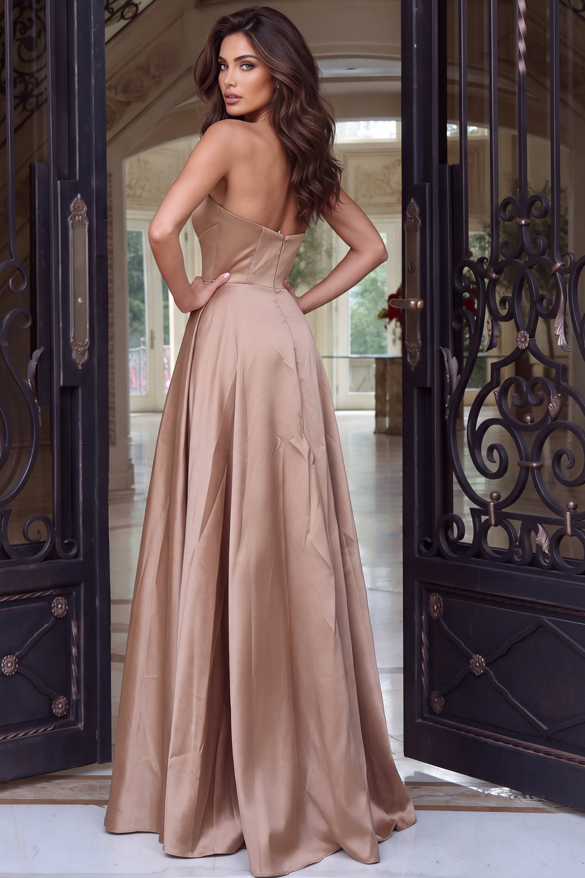 Seen from the rear, a mocha organza ball gown with bare back and sweeping skirt