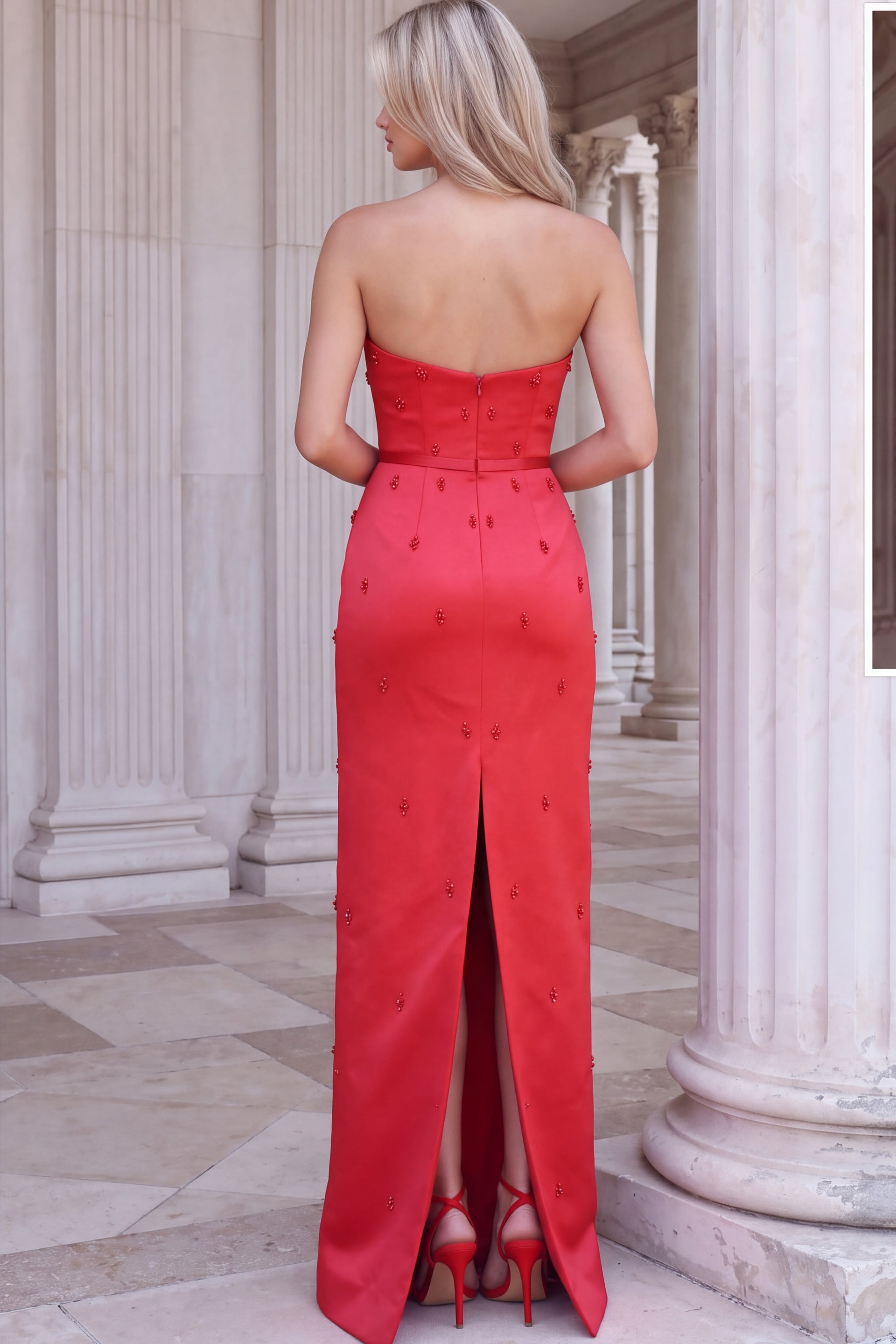 Back view of red satin column gown showing the strapless back and center back slit
