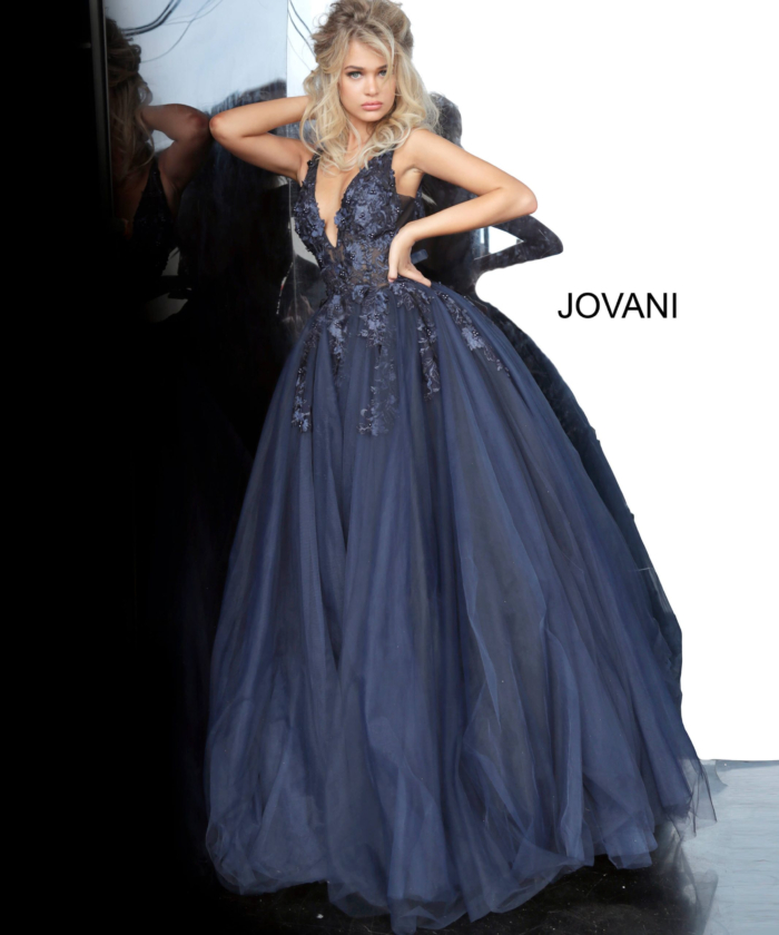 Model in navy Jovani 55634 gown with V-neckline and lace appliques.