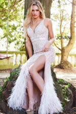 Model wearing Jovani 55796 ivory dress with intricate beadwork, V-neckline, and high slit.