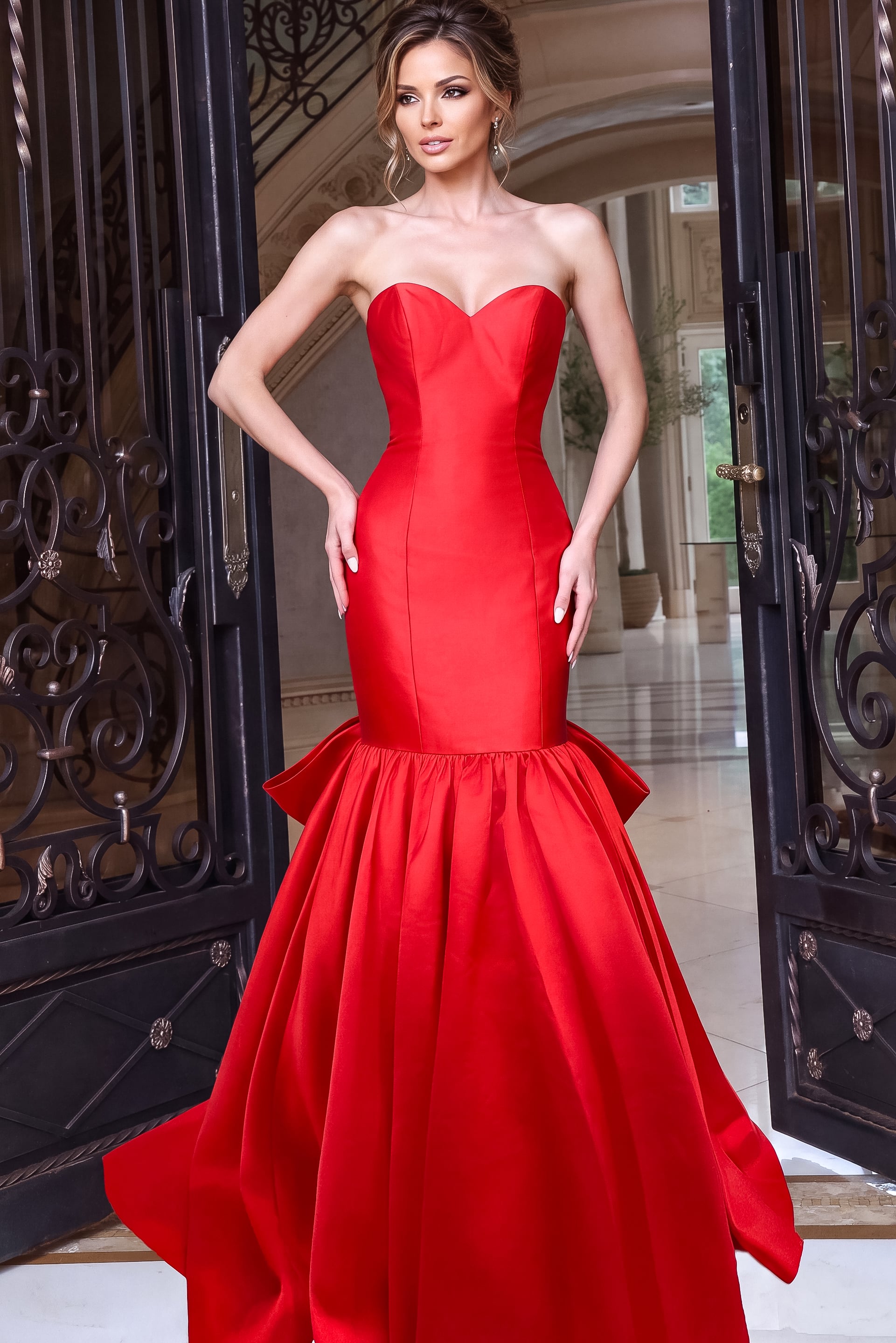 red strapless mermaid dress featuring a fitted silhouette and oversized bow at the skirt.