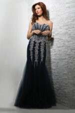Model wearing Jovani 5908 navy mermaid gown with intricate beading