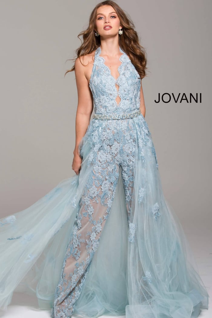 Model in Jovani 60124 light blue, halter neck dress with a flowing translucent overlay.