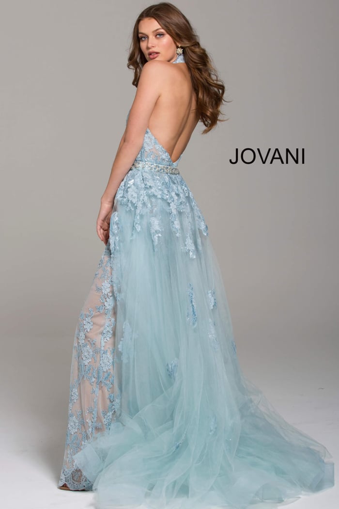 Model showing back of Jovani 60124 gown in light blue with open back and lace details.