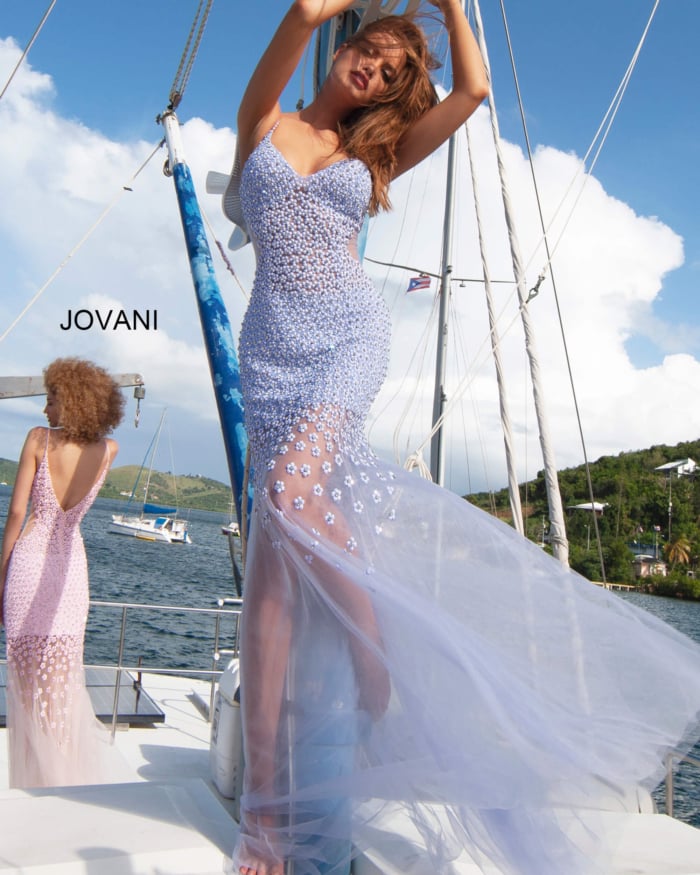 Model wearing Jovani 60695 gown in blue, embellished with floral appliques, front view.