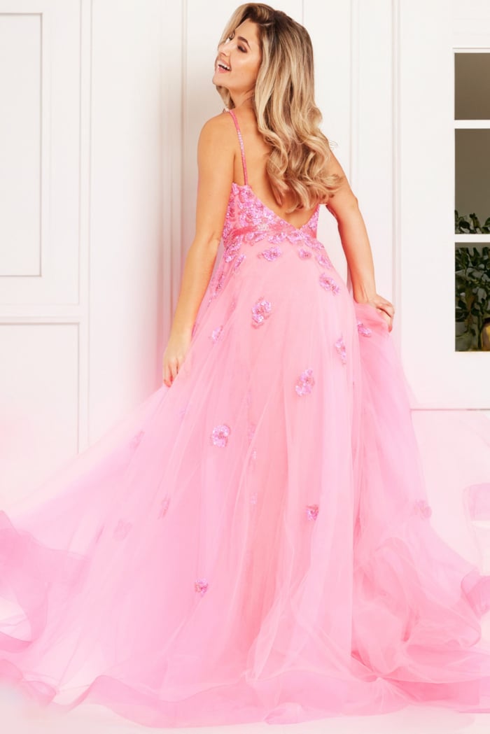 Back view of model in Jovani 62929, showcasing the gown's low back detail with floral appliqués.